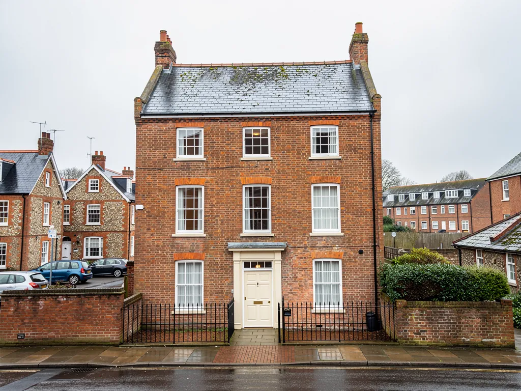 A Georgian brick town house with a slate roof and parapet in a Hampshire market town